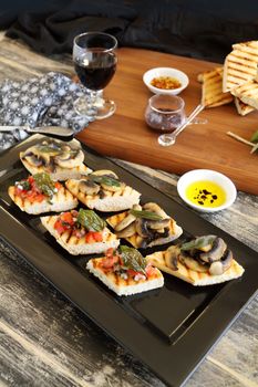 A selection of finger food with mushrooms, tomato and onion including brushette and dips.