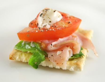 Ham tomato lettuce and mayo on a cracker snack