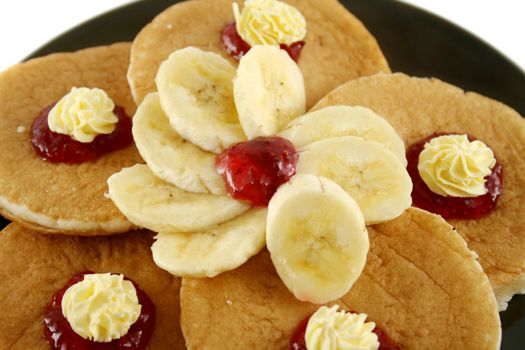 Delicious pancakes with butter swirls and strawberry jam with banana.