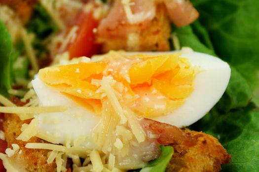 Caesar salad with egg, parmesan cheese, bacon, lettuce, cherry tomatoes and croutons.