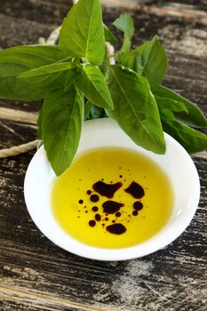 Dipping condiment of olive oil and balsamic vinegar with sage.