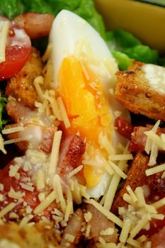 Fresh Caesar salad with lettuce, cherry tomatoes, parmesan cheese, egg, bacon and croutons.