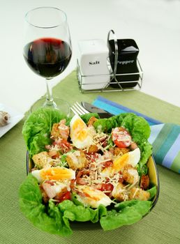 Fresh Caesar salad with lettuce, cherry tomatoes, parmesan cheese, egg, bacon and croutons.