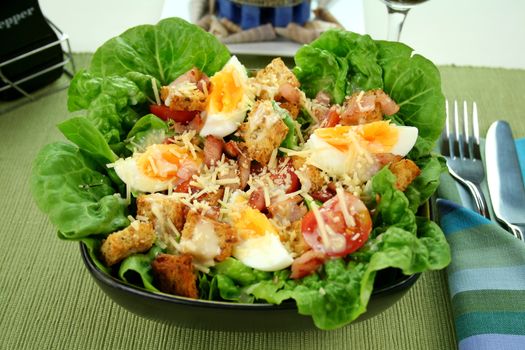 Fresh Caesar salad with lettuce, cherry tomatoes, parmesan cheese, egg, bacon and croutons.