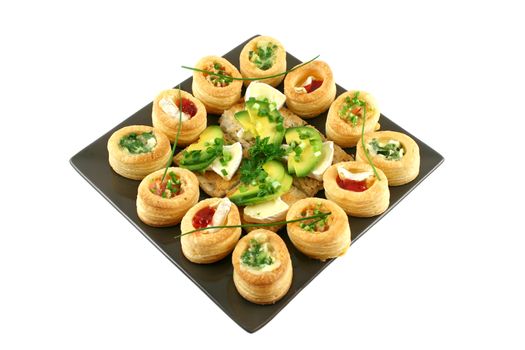 Assorted vol au vonts and avocado and camembert bites on a platter.