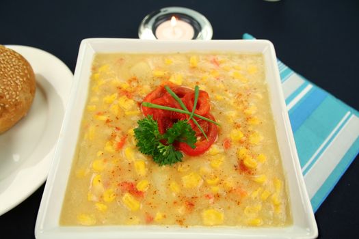 Roasted capsicum chili and corn chowder in a dark blue table setting.