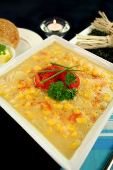 Roasted capsicum chili and corn chowder in a dark table setting.