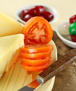 Sliced fresh garden tomato with cheddar cheese and cocktail onions.