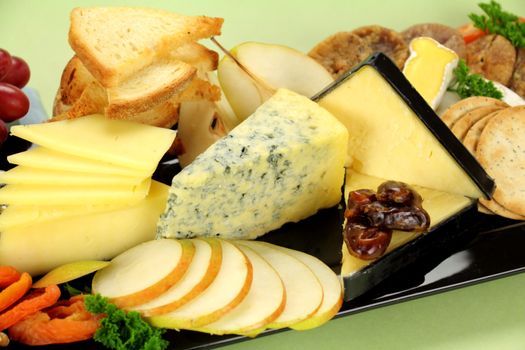 Delicious cheese platter with various cheeses and fruits ready to serve.