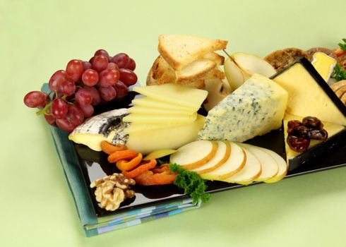 Delicious cheese platter with various cheeses and fruits ready to serve.