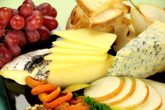 Delicious cheese platter with various cheeses and fruits ready to serve.