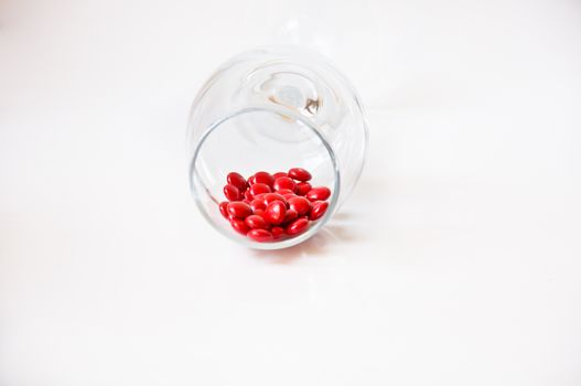 red pill in glass on white background