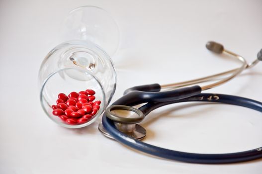 red pill in glass on white background