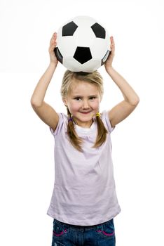 Cute girl playing football, happy child, young female goalkeeper enjoying sport game, holding ball, isolated portrait of a preteen smiling and having fun, kids activities, little footballer 