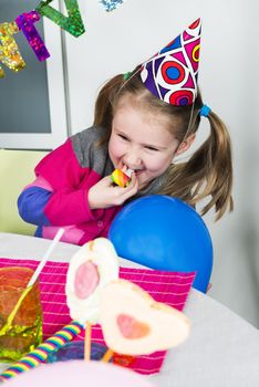 Happy little girl how have fun in a birthday party 