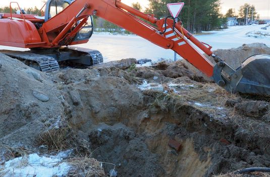 Crawler excavator Tractor Digging a Trench on the roadside