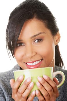 Young woman drinking something from big mug, isolated on white