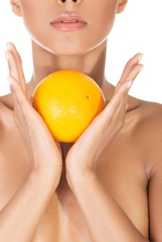 Young beautiful spa woman with orange in her hand, isolated on white