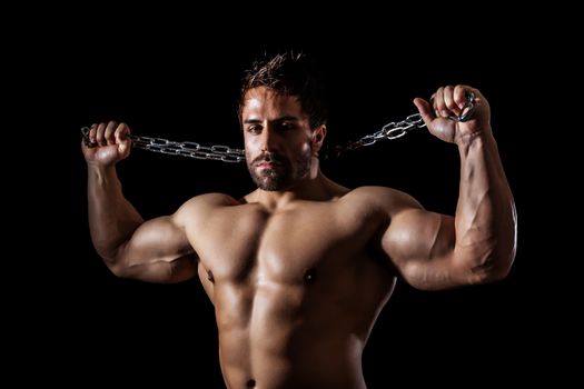 A handsome young muscular sports man with a chain