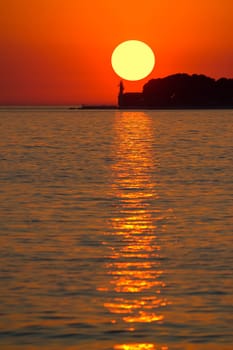 Sunset over lighthouse in Zadar vertical view, Dalmatia, Croatia