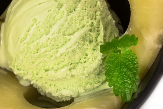 pistachio ice cream with pineapple rings and mint leaf