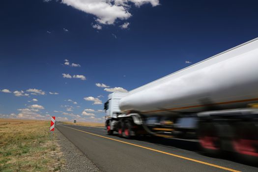 White tanker truck transporting fuel along the tar highway