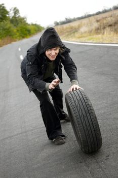Man holding a wheel on the road