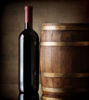 Bottle of red wine and a wooden barrel