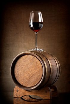 Red wine and glass with wooden barrel