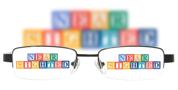 Letter blocks spelling near sighted with a pair of glasses. Isolated on a white background.