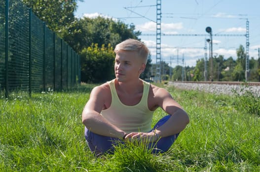 Man in t-shirt sitting in a grass