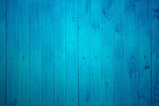 Part of wooden fence with tightly fastened new boards painted in blue color