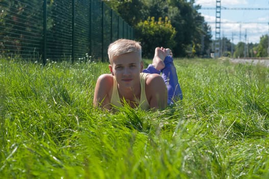 Man in yellow t-shirt lying in a grass