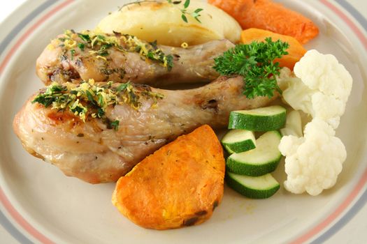 Delicious roasted chicken drumsticks with baked vegetables.