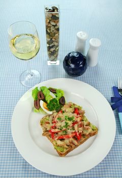 Grilled open chicken sandwich with avocado, peppers and cheese with a side salad.