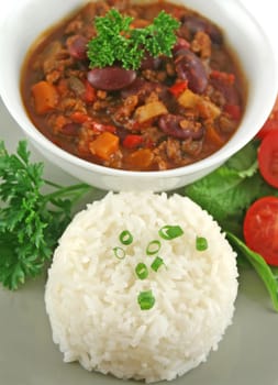 Colorful and spicy chili con carne with a rice stack ready to serve.