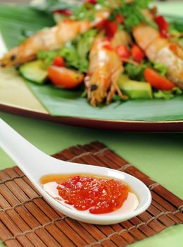 Delicious Asian chilli shrimp skewers with salad and sweet chili sauce.