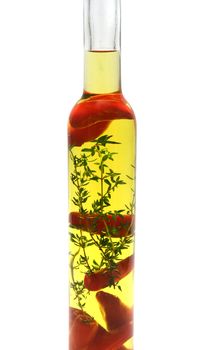 Red chillies and thyme preserved in a bottle of olive oil.