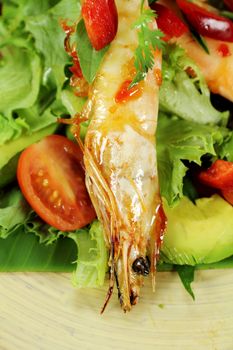 Delicious spicy Asian shrimps served with salad and vegetables.
