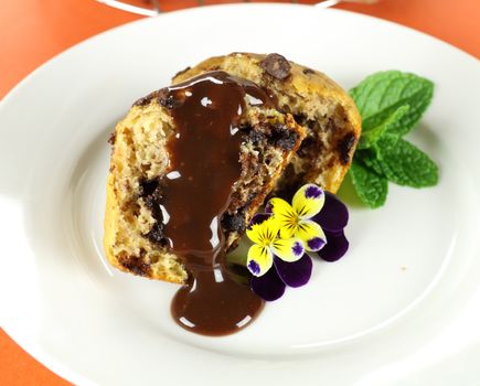 Yummy choc chip muffin dripping with chocolate sauce.