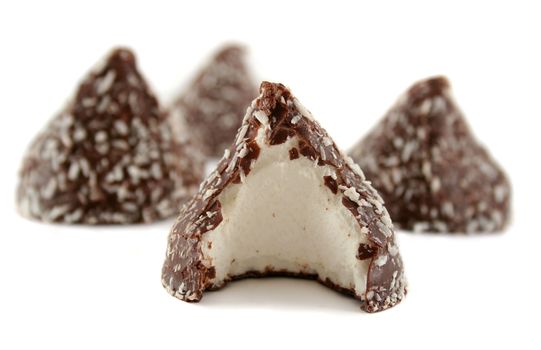 Chocolate and coconut covered marshmallow cones with a bite out of one.