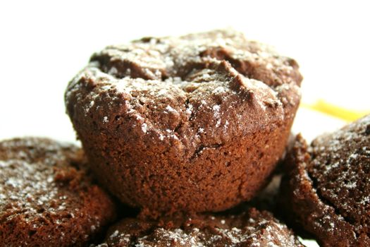 Chocolate brownies stacked up sprinkled with icing sugar.