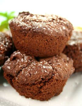 Chocolate brownies stacked up sprinkled with icing sugar.