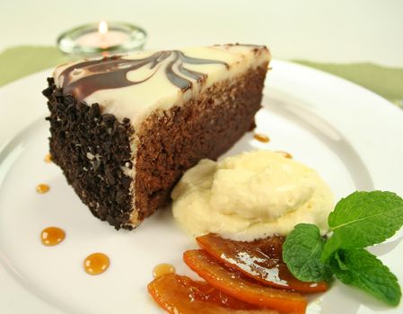 Rich chocolate cake with orange toffee and cream with a mint garnish.