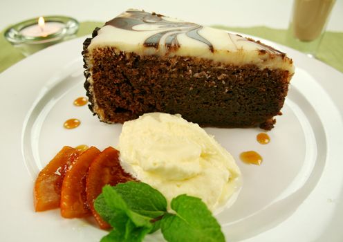 Rich chocolate cake with orange toffee and cream with a mint garnish.