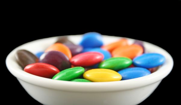 Assorted crunchy and colorful chocolate buttons in profile