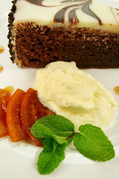 Rich chocolate cake with orange toffee and cream with a mint garnish.