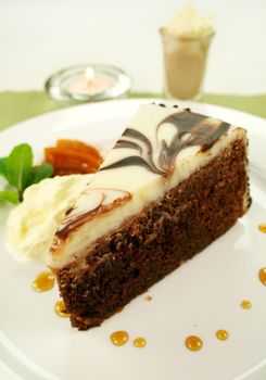 Rich chocolate cake with orange toffee and cream with a mint garnish.