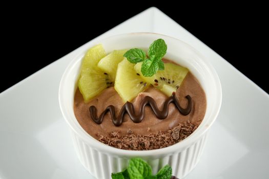 Chocolate mousse with yellow kiwi fruit and mint.