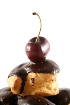 Fresh cherry sitting atop a chocolate profiterole
